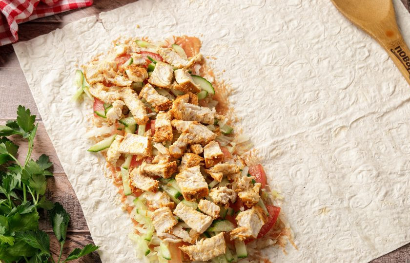 1. Этап. Шаурма в аэрогриле: На овощи выложите куриное филе. Начинку берите в том количестве, в котором больше любите. Кому-то нравится побольше мяса, а кому-то соуса или овощей. Если любите с луком, можно добавить нарезанную луковицу, добавить тёртый сыр, болгарский перец и т.д.