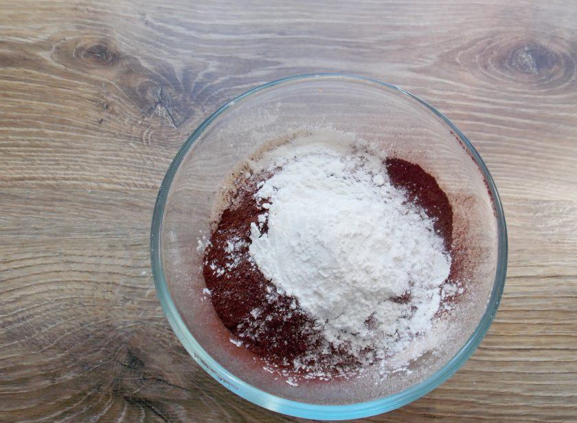 1. Этап. Капкейки Баунти: Добавьте в миску с мукой и какао разрыхлитель и кукурузный крахмал, перемешайте. Если нет крахмала, замените его таким же количеством муки.