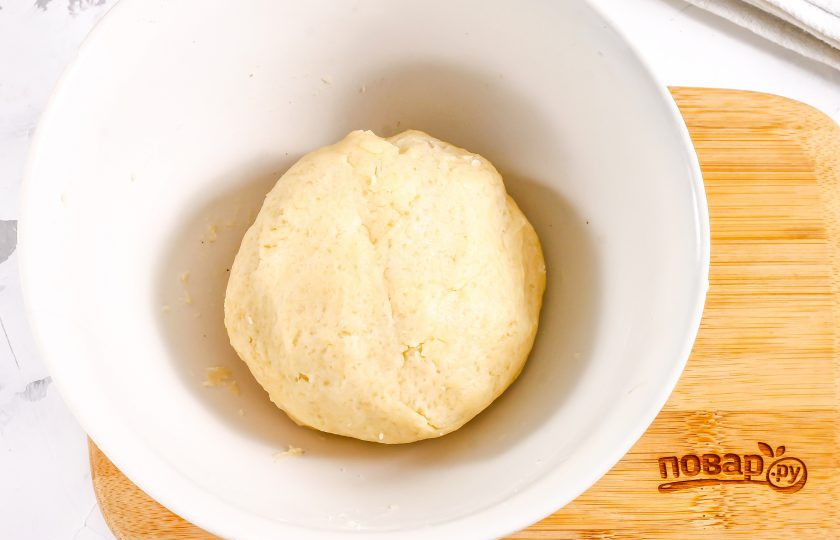 1. Этап. Сметанник из песочного теста: Соберите крошку из теста в колобок, накройте пищевой пленкой и поместите в холодильник на 20 минут.