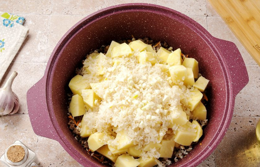 1. Этап. Картофель с фаршем и рисом: Затем добавьте нарезанный кубиками картофель, промытый рис и измельчённый чеснок.