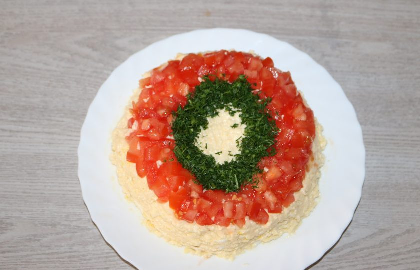 1. Этап. Салат Карнавал: Сверху салата выложите помидоры нарезанные кубиком и мелко нарезанный укроп.