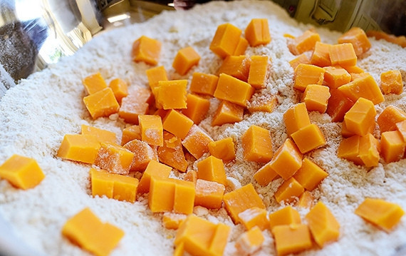 1. Этап. Песочные сконы с сыром и перцем: 3. Добавьте в тесто кубики твердого сыра.