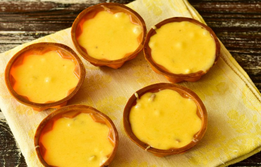 1. Этап. Капкейки с орехами: Разлейте тесто в силиконовые формочки.