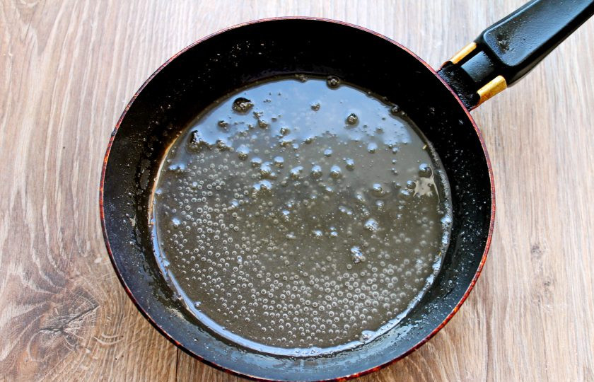 1. Этап. Карамелизированная клубника: В сковороду с толстым дном всыпьте сахар, влейте воду и лимонный сок. Поставьте на медленный огонь. Не мешая, доведите до кипения. Варите карамель до золотистого цвета. Снимите с огня и немного остудите.