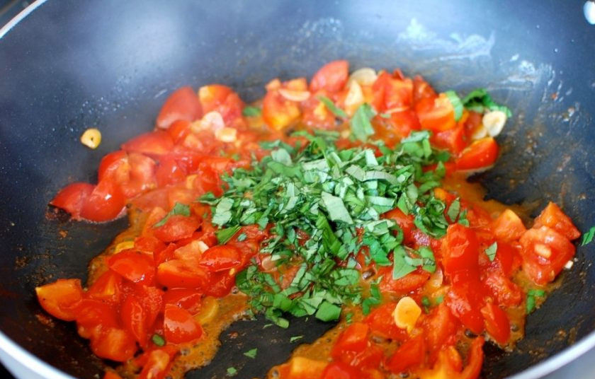 1. Этап. Маникотти из блинов с сырной начинкой: 7. Нарежьте мелко помидоры и оставшийся базилик, добавьте все в сковороду к чесноку.