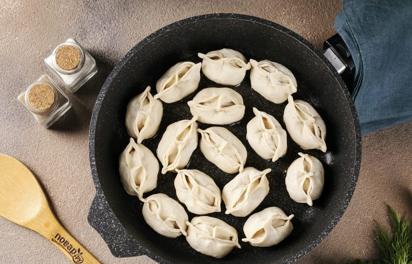 1. Этап. Манты без мантоварки: Разогрейте сковороду с маслом и выложите готовые манты. Манты не должны лежать вплотную, так как в процессе они ещё увеличатся в размере.