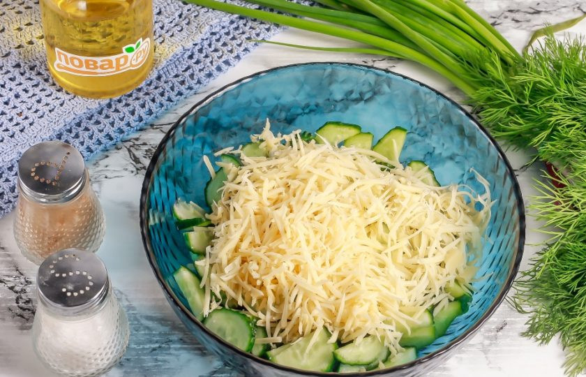 1. Этап. Салат с яйцом, огурцом, зелёным луком и сыром: Натрите в емкость твердый сыр на терке с крупными или мелкими ячейками.