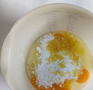 1. Этап. Лимонно-мандариновый миндальный пирог: К яйцам добавить сахарную пудру и цедру лимона, взбить до однородности.