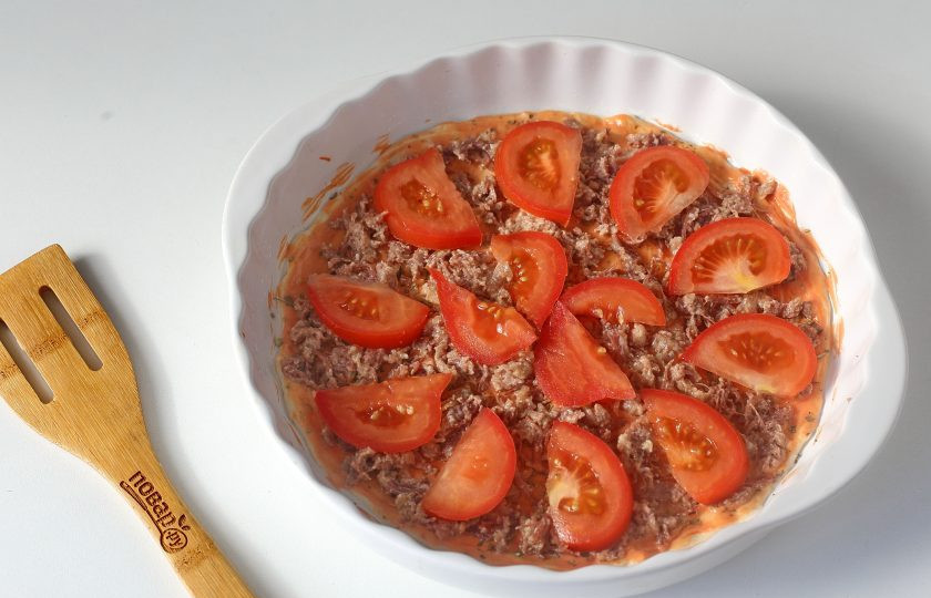 1. Этап. Пицца с тушенкой: На тушенку выложите нарезанные дольками помидоры.