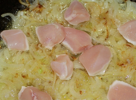 1. Этап. Плов с куриным филе: Теперь можно приступить к приготовлению самого плова. Наливаем в казан растительное масло и ставим его на огонь. Когда масло нагреется, выкладываем в него целую луковицу и обжариваем ее, пока она не потемнеет (она уберет лишние запахи). Луковицу теперь можно выбросить, а в масле начинаем жарить нарезанный полукольцами лук. Обжариваем его до золотистого цвета, затем добавляем куриное филе.