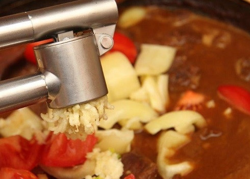 1. Этап. Говядина с овощами: Добавляем очищенный и измельченный чеснок.