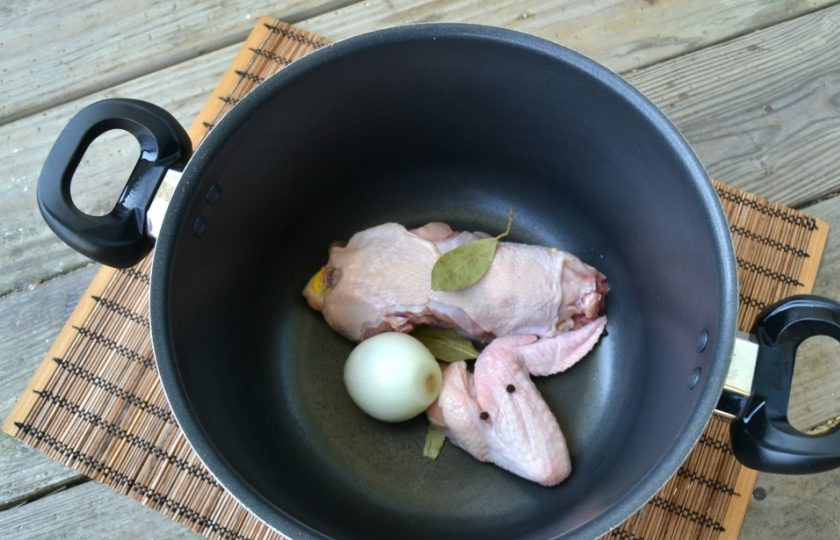 1. Этап. Ароматный куриный бульон: 2. В кастрюлю выложите спинку и одно крыло. Добавьте очищенный лук, перец и лавровый лист.