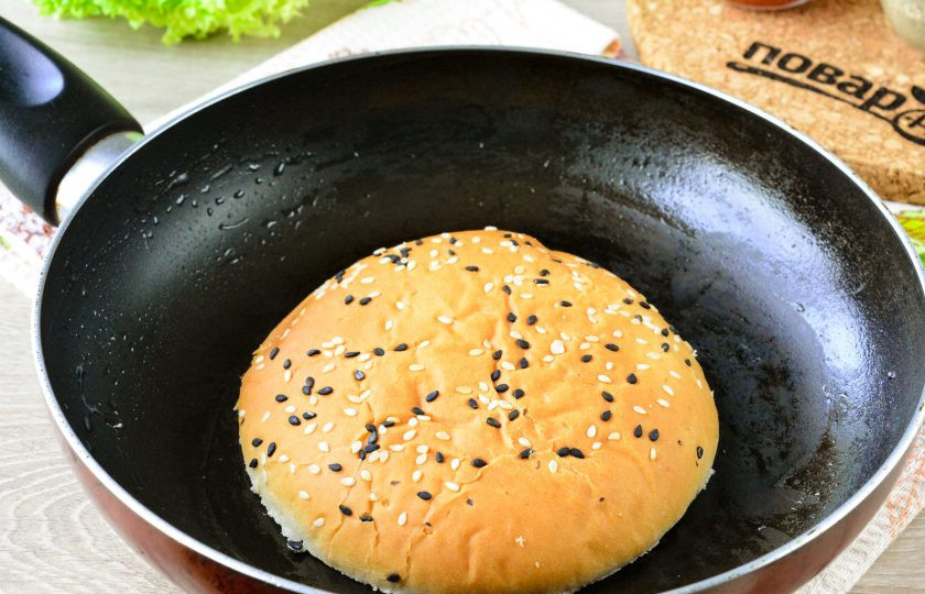 1. Этап. Бургер с курицей, яблоком и сыром: Разрежьте булочку для бургера пополам, каждую половину обжарьте в сухой сковороде, чтобы она стала хрустящей.