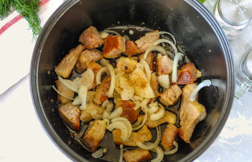 1. Этап. Свинина в соевом соусе в мультиварке: Очистите репчатый лук от шелухи и промойте в воде, нарежьте овощ полукольцами и добавьте в емкость за 2-3 минуты до окончания жарки. Влейте соевый соус, посолите и поперчите мясо. Добавлять специи нужно в самом конце, так как соль, добавленная в начале приготовления, вытянет из мяса сок и оно станет жестким.