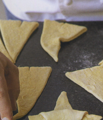 1. Этап. Круассаны из слоеного бездрожжевого теста: 3. Далее аккуратно сверните треугольники к меньшему краю, как бы наматывая тесто.