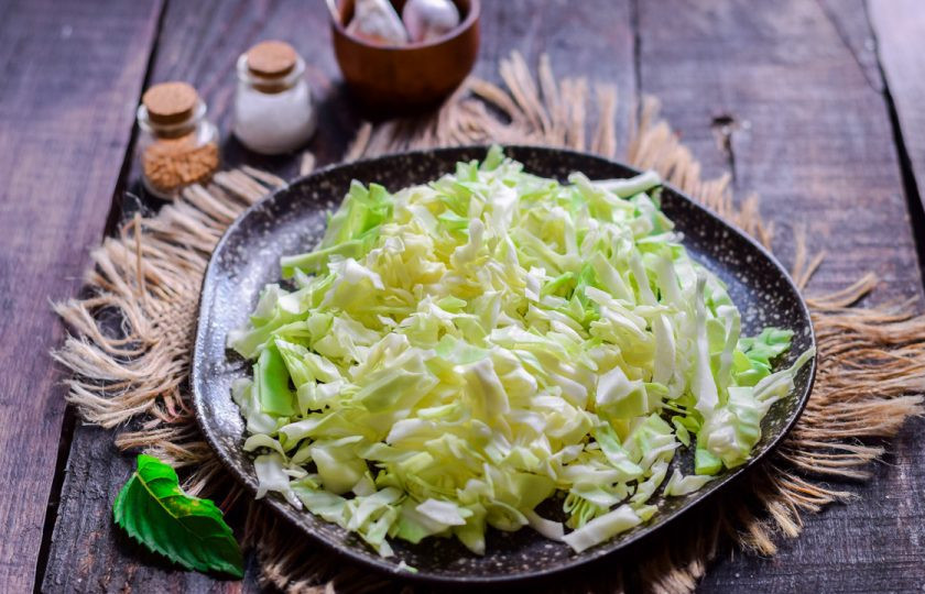 1. Этап. Тушеная молодая капуста: Сполосните и снимите верхние листья у вилка капусты. Нарежьте капусту тонкой соломкой.