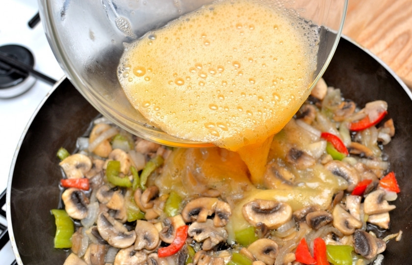 1. Этап. Омлет с сыром и овощами: Залейте яичной массой овощи с грибами.