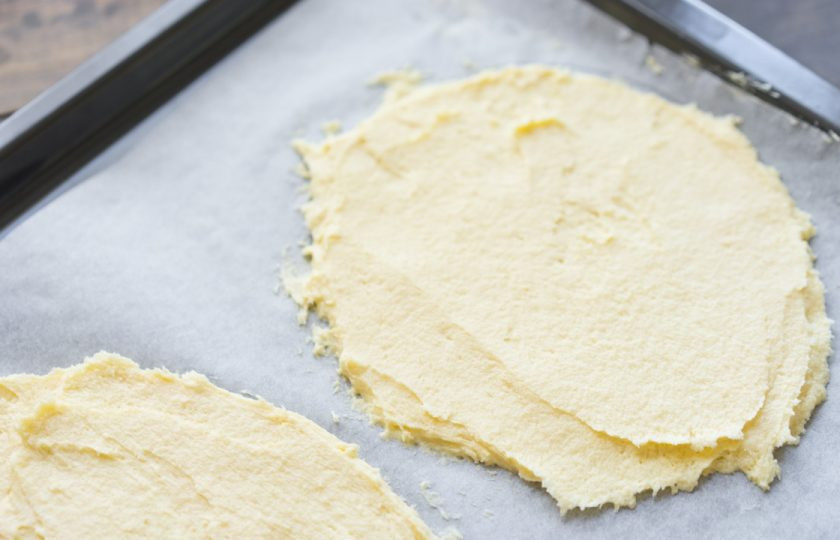 1. Этап. Десерт Птичье молоко: 5. Разделяем его на две части, выкладываем на противень и отправляем в духовку. Противень хорошо застилаем пергаментом, чтобы коржи не прилипли. Поскольку тесто густое, но не на столько, чтобы его раскатать скалкой, я формирую их при помощи кондитерской лопатки.