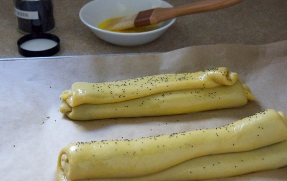 1. Этап. Маковый штрудель: 4. Сложите один край на другой — и получится рулет. В миске взбейте куриный желток и смажьте им выпечку, украсьте семенами мака.