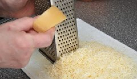 1. Этап. Домашний Макдоналдс - куриные наггетсы: 2. Натираем сыр на мелкой терке в отдельную посуду. В другой емкости разбиваем куриные яйца, солим и приправляем их, после чего хорошенько разбалтываем вилкой.