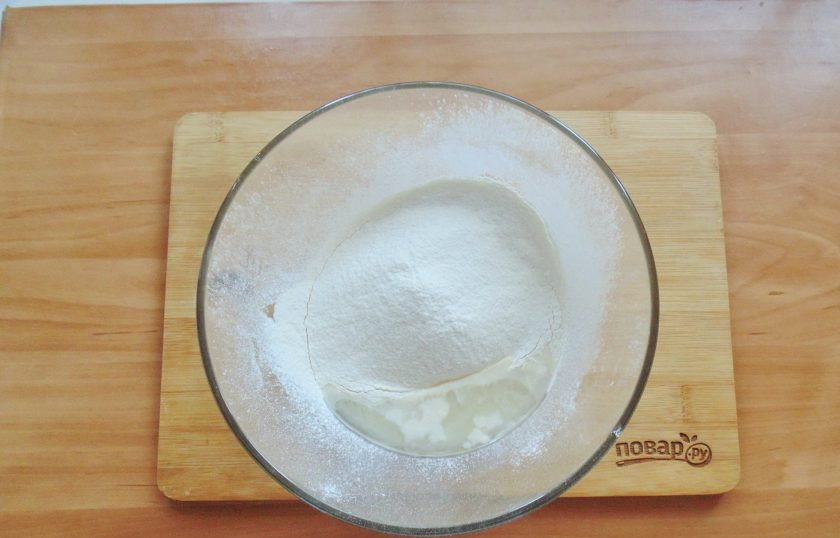 1. Этап. Испанская пицца: Постепенно добавьте просеянную муку и замешивайте тесто.