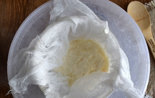 1. Этап. Дехин: Возьмите охлажденный йогурт, добавьте соль. Проложите сито марлей в 4 слоя, влейте йогурт. Распределите его по всей поверхности. У меня вот такая специальная самодельная конструкция. Одно большое пластиковое ведро с крышкой, два маленьких ведерка, одно из них с маленькими дырочками, как сито. В центре крышки отверстие, диаметр которого соответствует диаметру маленького пластикового ведерка.