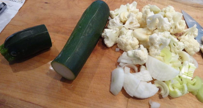 1. Этап. Суп с кабачками: 1. Вымойте кабачок и отрежьте четвертую часть (для украшения), вымойте и разберите на соцветия капусту, вымойте порей и нарежьте его кусочками, очистите и нарежьте полукольцами репчатый лук. Очистите чеснок и картошку.