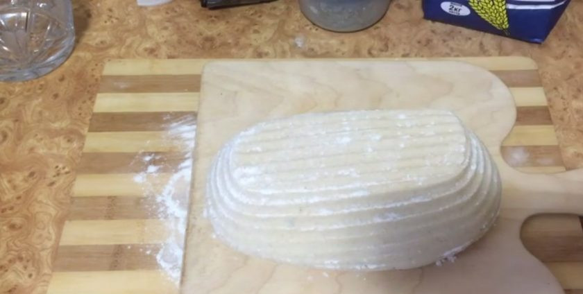 1. Этап. Хлеб из муки двух сортов: Аккуратно переложите хлеб на пергамент (если вы его расстаивали в корзинке). Стряхните лишнюю муку, сделайте несколько надсечек, сбрызните хлеб водой.