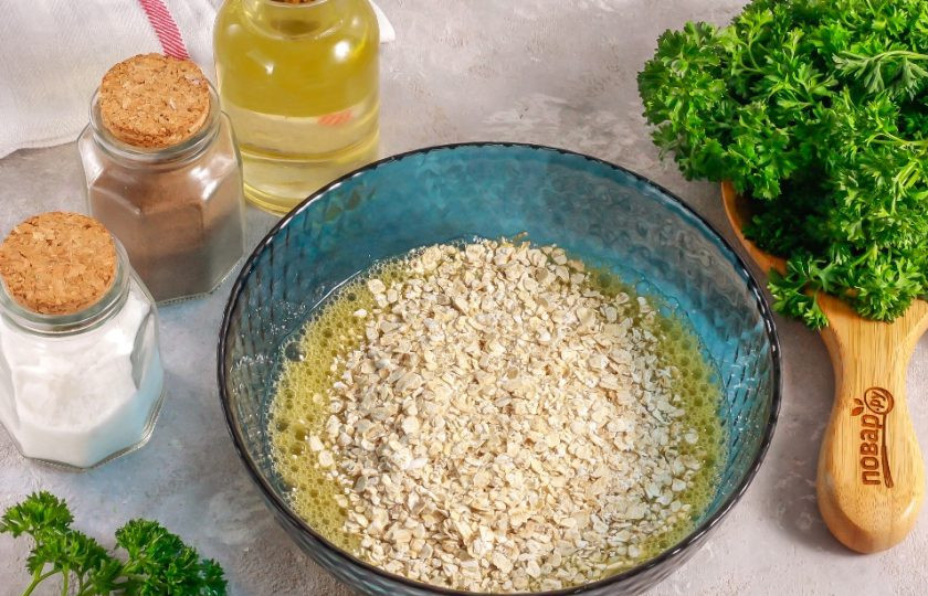 1. Этап. Овсяноблин с творогом: Всыпьте овсяные хлопья быстрого приготовления и перемешайте. Оставьте примерно на 5 минут для набухания.