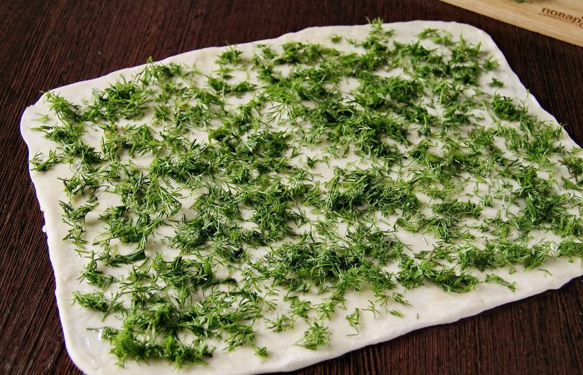 1. Этап. Лепешки с укропом: Затем подпыляя стол мукой, раскатайте тесто в форме прямоугольника. Смажьте тесто растительным маслом, посыпьте измельченным укропом и посыпьте солью по вкусу.