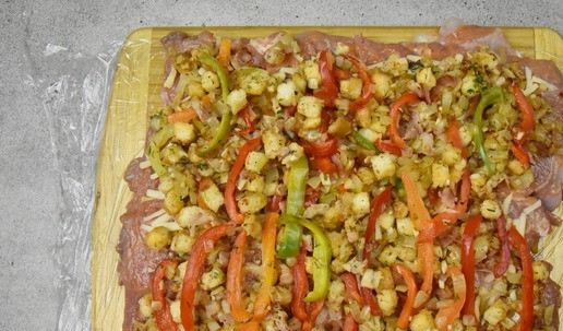 1. Этап. Рулет из индейки с беконом: На сырный слой выложите подготовленную начинку. Аккуратно сверните всю конструкцию в тугой рулет.