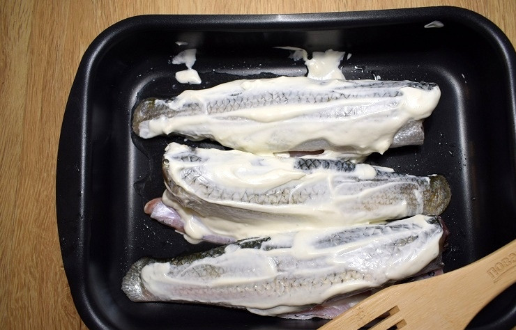 1. Этап. Запеченная рыба под хрустящей корочкой: Форму для запекания смажьте маслом, выложите в неё рыбу. Смажьте сметанной смесью.