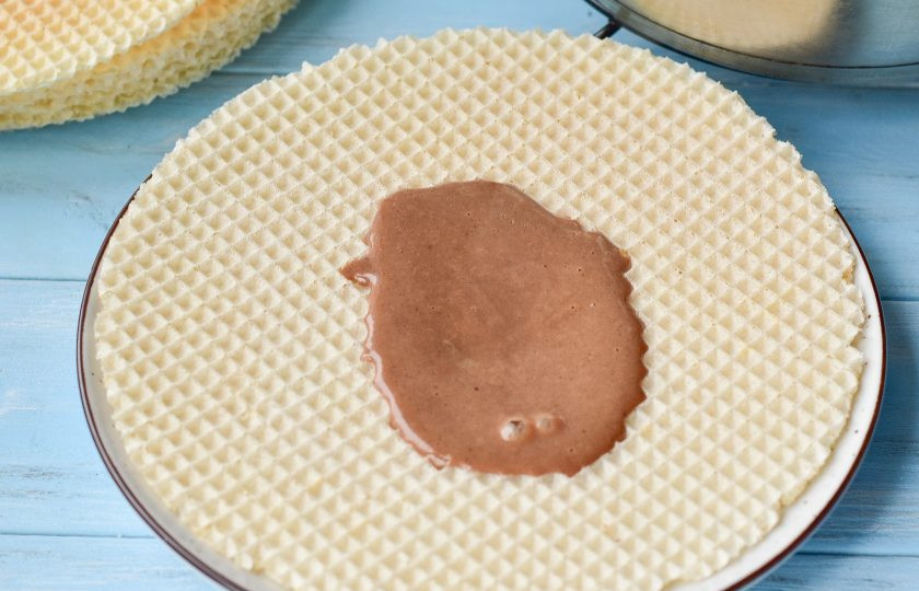 1. Этап. Шоколадно-вафельный торт: Выложите на тарелку корж и смажьте его кремом.