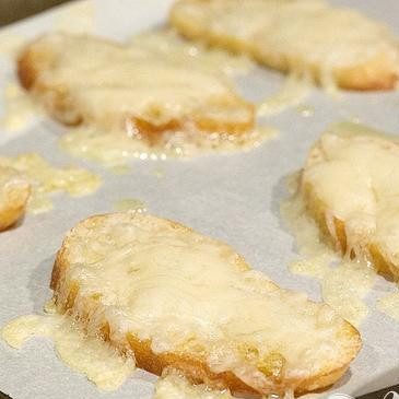 1. Этап. Суп с запеченным чесноком, помидорами и сыром: 2. Вынуть тосты из духовки, посыпать каждый 1 столовой ложкой сыра Грюйер и запекать в духовке до тех пор, пока сыр не расплавится. Вынуть хлеб из духовки, разрезать каждый ломтик по косой, чтобы получилось 12 штук, и держать в тепле.