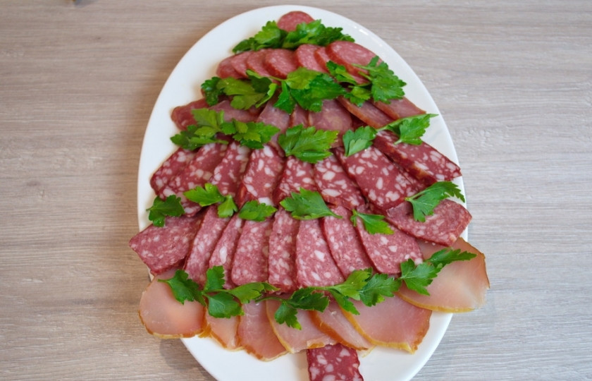 1. Этап. Мясная нарезка в виде ёлочки: Петрушкой или укропом подчеркните уровни ёлки. Из одного кусочка колбасы соорудите ствол ёлки.