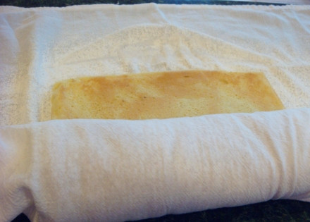 1. Этап. Бисквитные рулеты с начинкой: 5. Переложите бисквит на чистое полотенце и аккуратно сверните. Параллельно вымойте, обсушите и нарежьте клубнику. Добавьте немного сахара, дайте ей постоять минут 5, чтобы образовался сок.