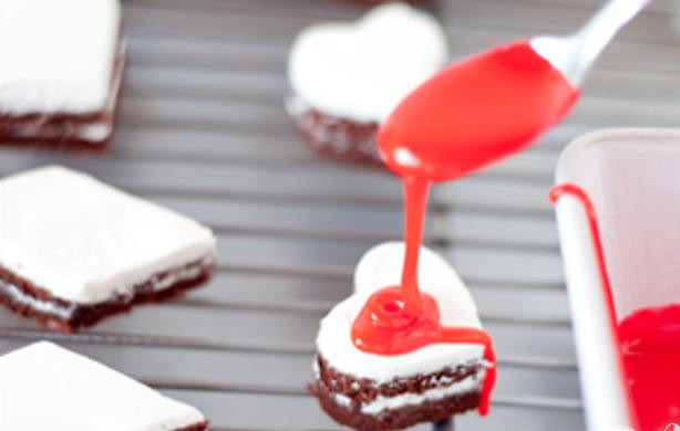 1. Этап. Праздничные шоколадные пирожные с глазурью: 3. Чтобы сделать глазурь, смешать сахарную пудру, воду и кукурузный сироп в средней кастрюле на слабом огне. Готовить, помешивая, до растворения сахара. Снять с огня и перемешать с ванильным экстрактом и пищевым красителем, если используете его. Дать остыть в течение 5 минут перед использованием. Для приготовления шоколадной глазури добавьте 90 г растопленного шоколада в смесь вместе с ванилью и перемешать. Украсить пирожные глазурью по желанию.