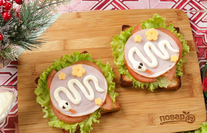 1. Этап. Бутерброды Змейка для праздничного стола: Остаётся украсить закуску по своему вкусу и подать к столу. Я вырезала из сыра цветочки, специальным приспособлением. Из маслин вырезала глазки, а из шкурки помидора язычок.