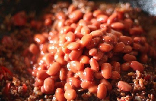 1. Этап. Плов из красного риса: Когда рис будет почти готов, на сковороду следует выложить консервированную фасоль. Снова все перемешиваем и в течение 10 минут прогреваем плов на медленном огне, после этого выключаем огонь и пол часа настаиваем блюдо под крышкой.