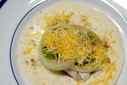 1. Этап. Фахитас с курицей: Обильно посыпаем тертым сыром.