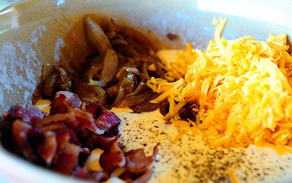 1. Этап. Киш с луком: Смешайте бекон, тёртый сыр чеддер, лук и яичный соус вместе.