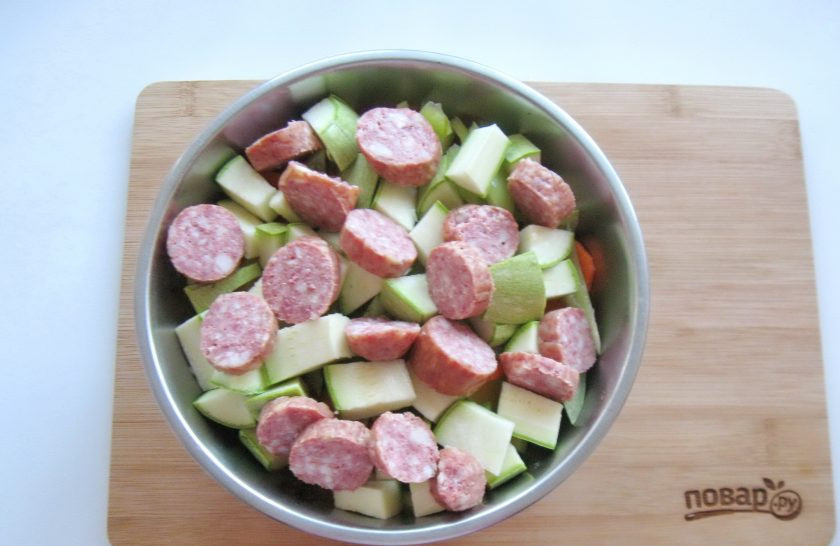1. Этап. Картофель с колбасками в духовке: Любые копченые колбаски по вашему вкусу нарежьте и добавьте к овощам.