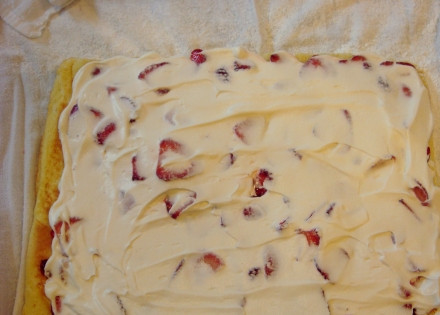 1. Этап. Бисквитные рулеты с начинкой: 7. Часть сливок выложите на клубнику и распределите ровным слоем.