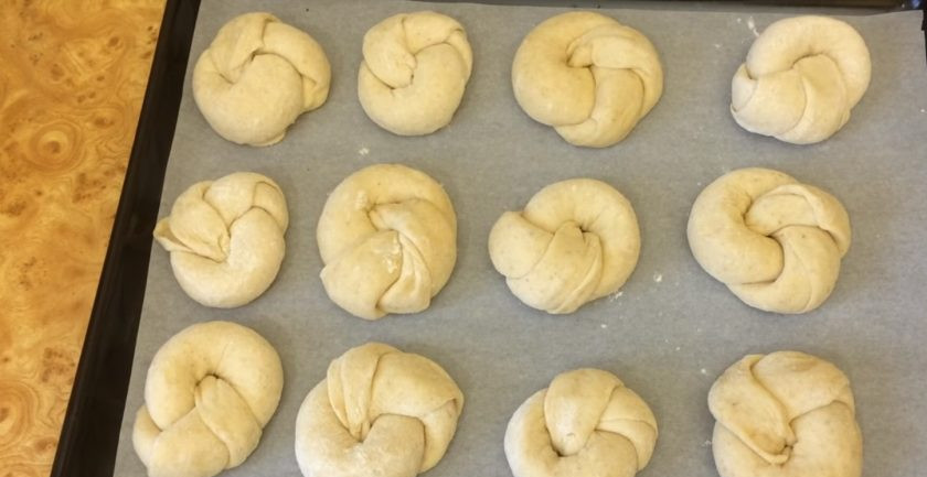1. Этап. Булочки к чаю сдобные: 7. Выложите заготовки на покрытый пергаментом противень. Накройте булочки пленкой и оставьте при комнатной температуре на 1 час.