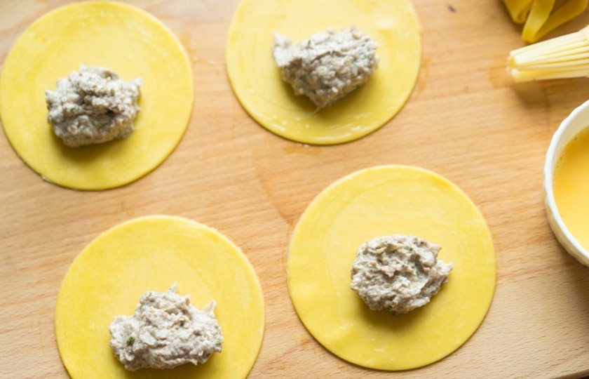 1. Этап. Итальянские пельмени: Раскатать можно и в ручную, но будьте готовы к тому, что это будет сложновато и потребуется время. Затем вырежьте кружочки из теста. И выложите в центр каждого начинку. Края кружочков слегка смажьте взбитым яйцом.