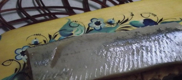 1. Этап. Канапе с селедкой: 4. Селедку очистить от кожи и костей. Готовое филе выложить сверху. Если разделать рыбу аккуратно не получилось, то лучше сразу делать небольшие канапе. Если кусочки филе достаточно большие, то нарезать канапе можно из готовых больших кусочков.