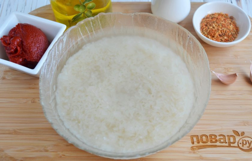 1. Этап. Плов на сковороде со свининой: Промойте рис под проточной водой. Вскипятите литр воды и залейте рис кипятком, оставьте на 30 минут для распаривания.