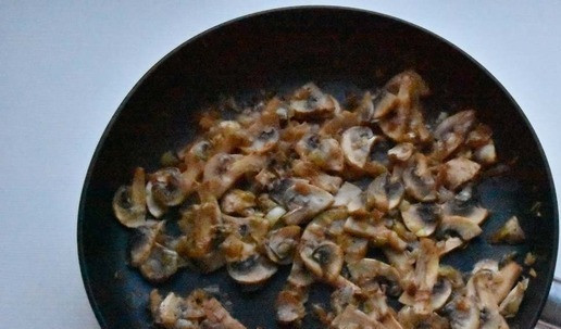 1. Этап. Сырный рулет с индейкой и грибами: В сковороду влить растительное масло, нагреть и выложить подготовленный лук. Пассеровать до золотистости и мягкости. Добавить грибы и обжаривать до испарения выделившейся влаги.