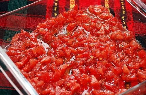 1. Этап. Морской судак в духовке: В форму для запекания выкладываем половину нарезанных помидоров.