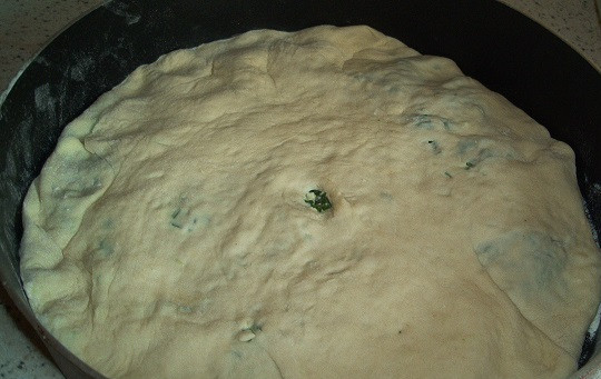 1. Этап. Осетинский пирог с зеленью: 6. Выложить в форму и сделать небольшое отверстие в центре. Отправить в разогретую духовку на 25-30 минут, пока верх не зарумянится. После запекания можно смазать пирог сливочным маслом, чтобы корочка была более сочной и блестящей.